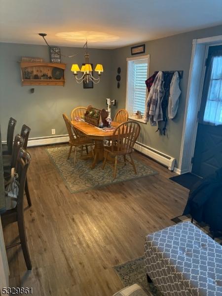 dining room featuring a baseboard radiator, dark hardwood / wood-style floors, and a notable chandelier