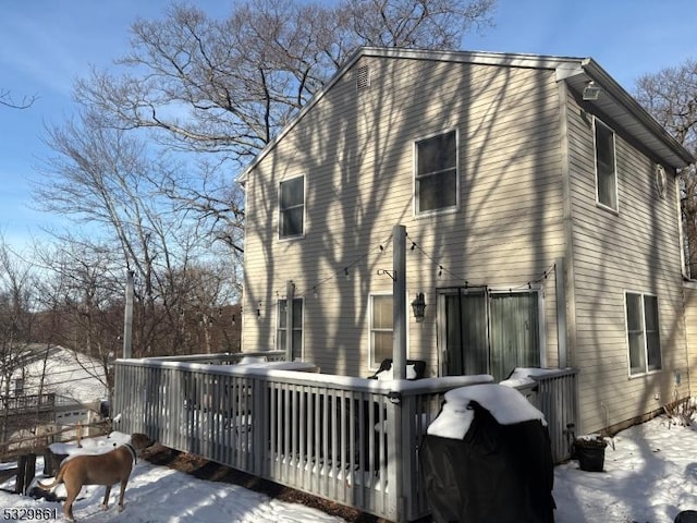 view of snowy exterior featuring a wooden deck