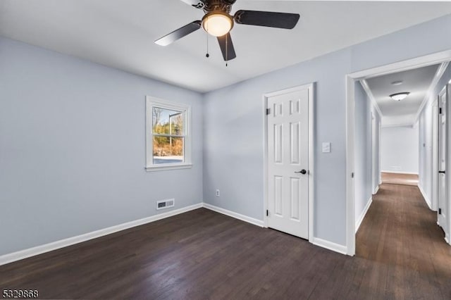 unfurnished bedroom featuring ceiling fan and dark wood-type flooring