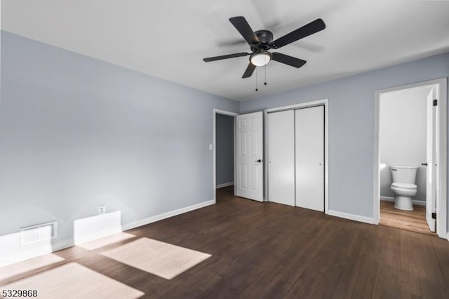 unfurnished bedroom featuring connected bathroom, ceiling fan, a closet, and dark hardwood / wood-style flooring