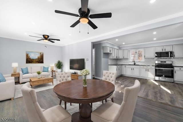 dining area with dark hardwood / wood-style floors, ceiling fan, ornamental molding, and sink