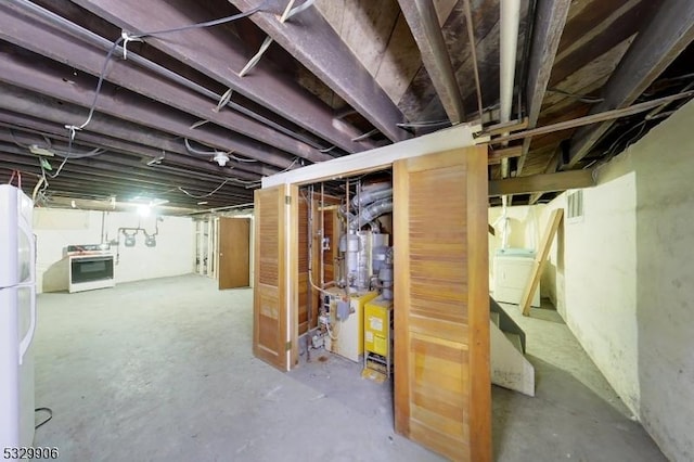 basement with washer / dryer and white fridge