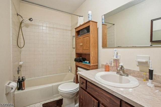 full bathroom featuring toilet, tiled shower / bath, tile patterned flooring, and vanity