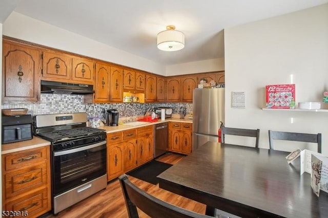 kitchen featuring sink, backsplash, dark hardwood / wood-style floors, and stainless steel appliances