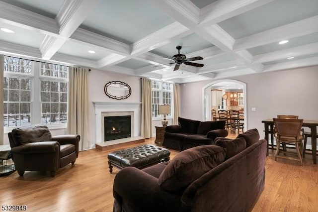 living room with coffered ceiling, ceiling fan, beam ceiling, and light wood-type flooring