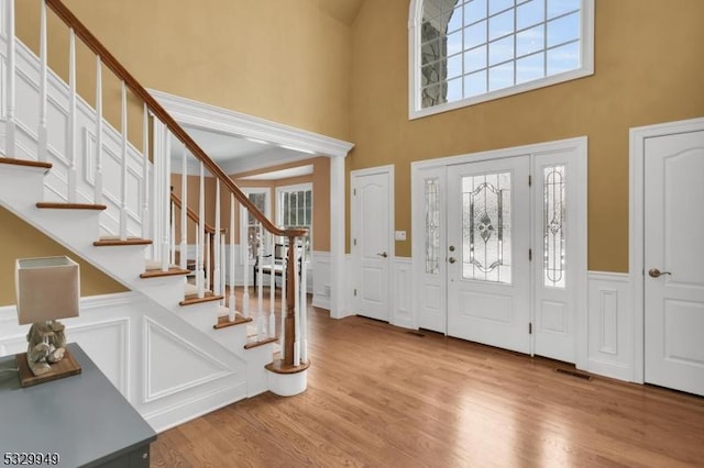 foyer with a wealth of natural light, a high ceiling, and light wood-type flooring