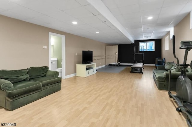 living room with a paneled ceiling and light wood-type flooring