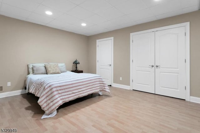 bedroom featuring light hardwood / wood-style flooring and a drop ceiling