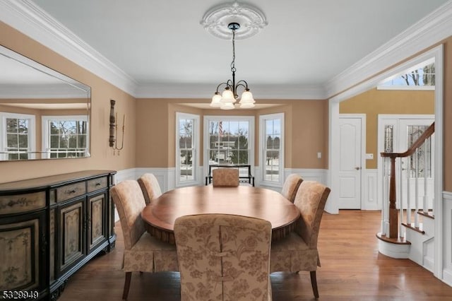 dining area featuring hardwood / wood-style flooring, crown molding, and a notable chandelier