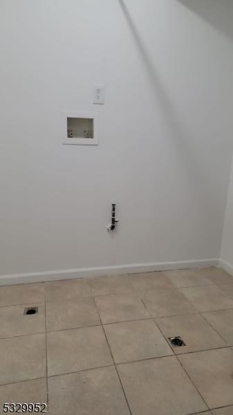 clothes washing area featuring washer hookup and light tile patterned flooring