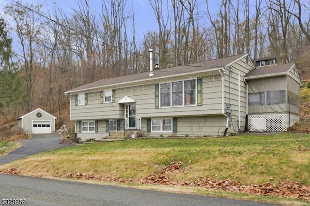 bi-level home with an outbuilding, a garage, and a front yard