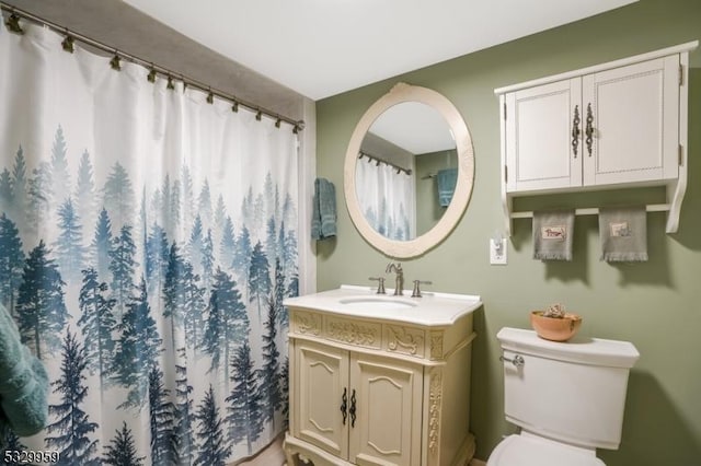 bathroom featuring walk in shower, vanity, and toilet