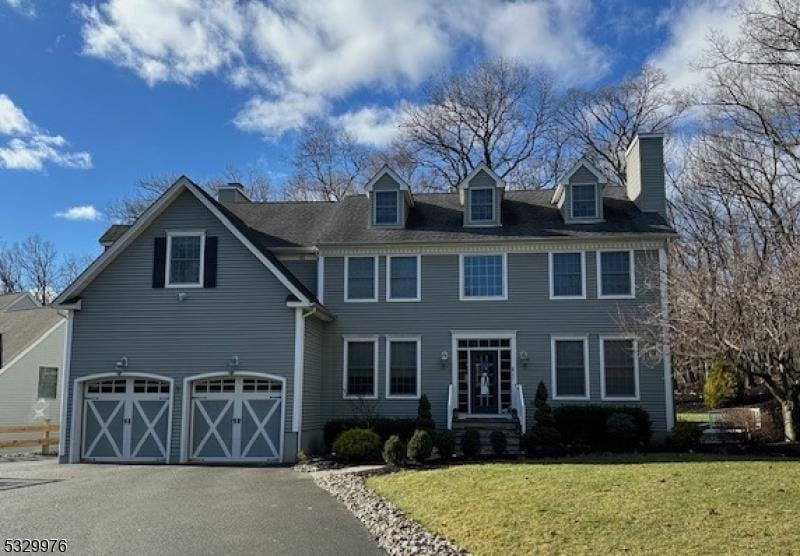 colonial house with a garage and a front lawn