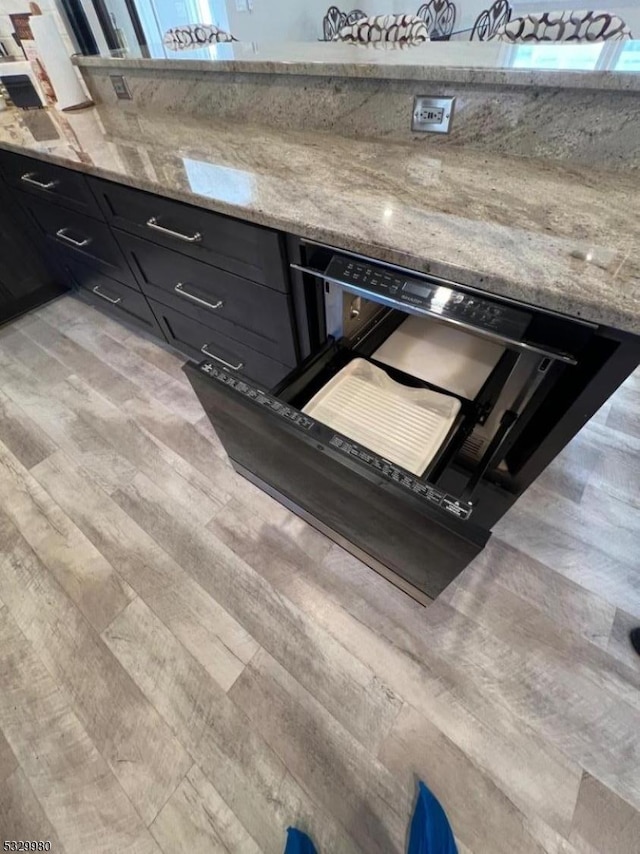 kitchen featuring light stone counters and light hardwood / wood-style flooring