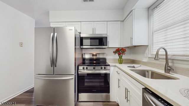 kitchen with white cabinetry, sink, stainless steel appliances, and dark hardwood / wood-style floors