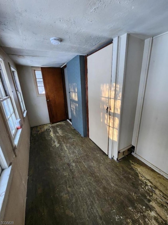 foyer entrance with dark wood-type flooring and a textured ceiling