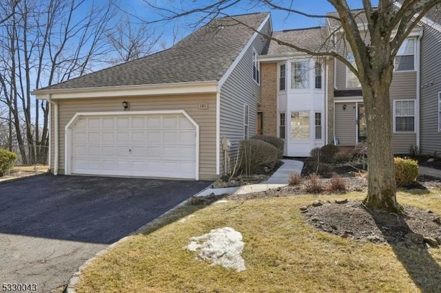 view of front of home with a garage and roof with shingles