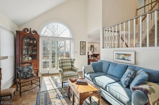 living area with stairs and high vaulted ceiling