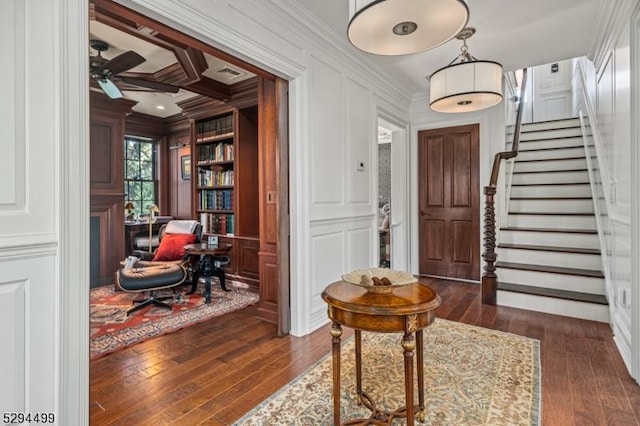 foyer featuring crown molding, ceiling fan, and dark wood-type flooring