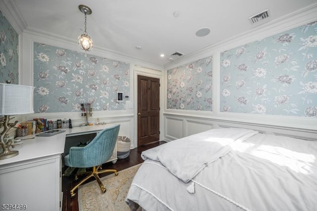 bedroom with hardwood / wood-style flooring, built in desk, and crown molding