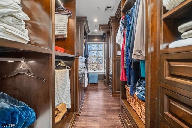 walk in closet with dark hardwood / wood-style flooring