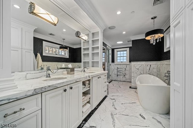 bathroom featuring a bathing tub, vanity, ornamental molding, and tile walls