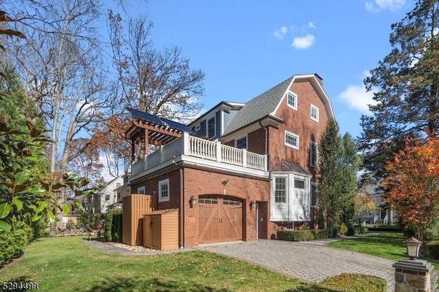 view of property exterior featuring a yard, a balcony, and a garage