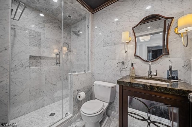 bathroom with ornamental molding, vanity, a shower with door, tile walls, and toilet