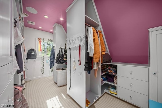 spacious closet featuring light colored carpet