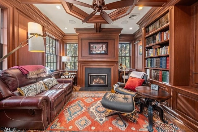 living area with built in features, plenty of natural light, and crown molding