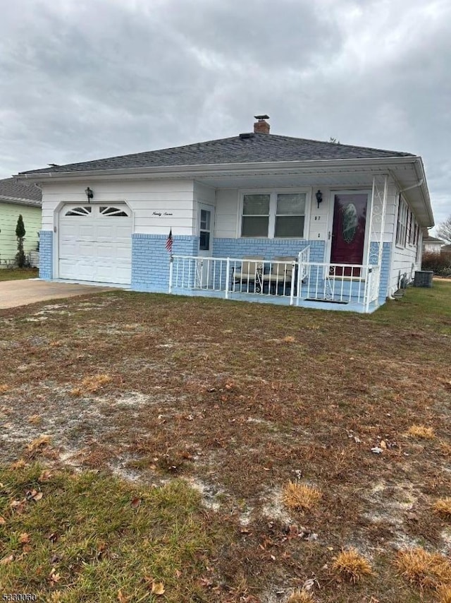 view of front facade featuring covered porch, a garage, and a front lawn