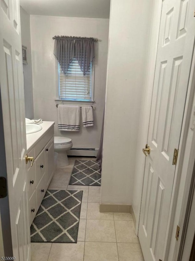 bathroom featuring baseboard heating, tile patterned floors, vanity, and toilet