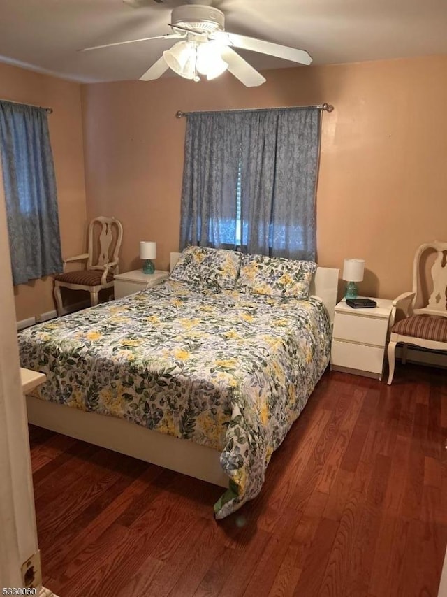 bedroom with dark hardwood / wood-style flooring and ceiling fan