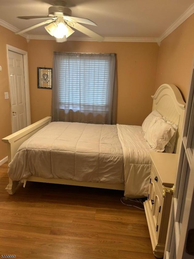 bedroom with wood-type flooring, ceiling fan, and crown molding