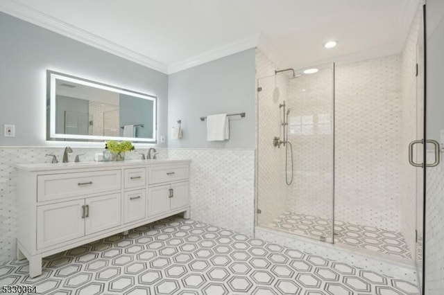 bathroom featuring a wainscoted wall, a stall shower, tile walls, and crown molding