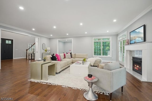 living room featuring recessed lighting, a premium fireplace, wood finished floors, baseboards, and ornamental molding