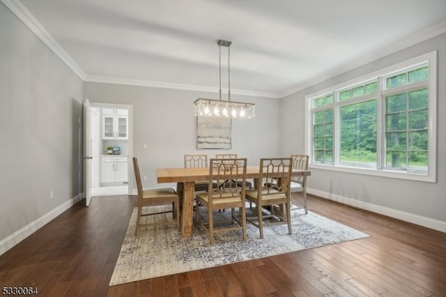 dining room featuring wood-type flooring, ornamental molding, and baseboards