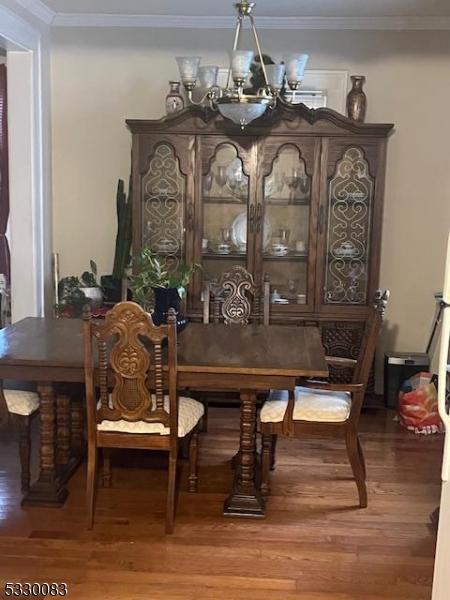 dining area featuring an inviting chandelier, crown molding, and hardwood / wood-style floors