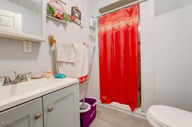 bathroom with a shower with shower curtain, vanity, and toilet