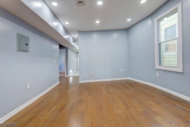 empty room with electric panel and light hardwood / wood-style flooring