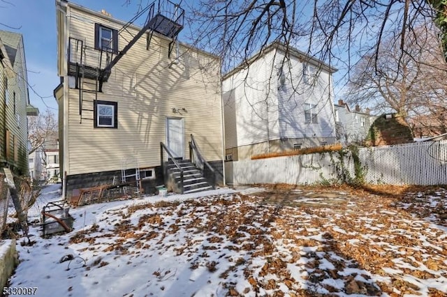 view of snow covered rear of property