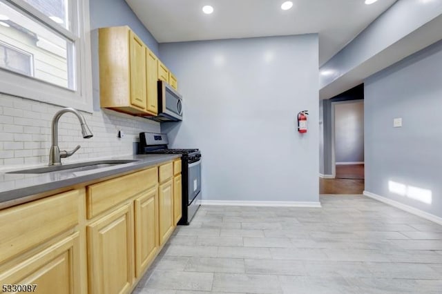 kitchen featuring decorative backsplash, light brown cabinets, sink, and stainless steel appliances