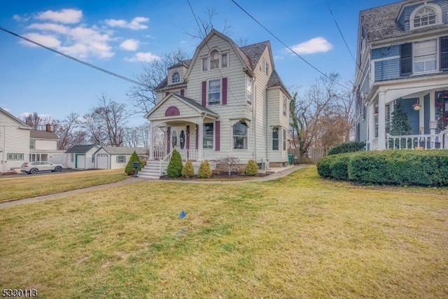 victorian house featuring an outdoor structure, a front lawn, and a porch