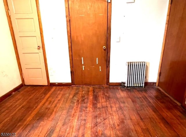 unfurnished room with wood-type flooring and radiator