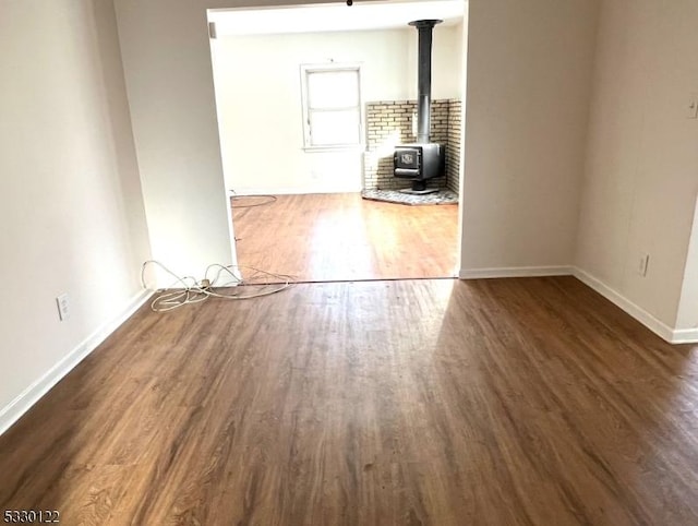 unfurnished living room featuring dark hardwood / wood-style floors and a wood stove