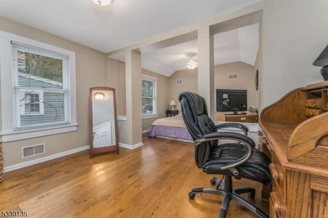 home office with ceiling fan, hardwood / wood-style floors, plenty of natural light, and lofted ceiling