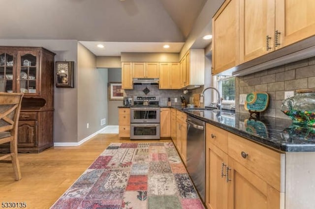 kitchen featuring lofted ceiling, light brown cabinets, stainless steel appliances, sink, and light hardwood / wood-style flooring