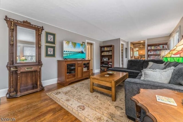 living room featuring built in shelves and hardwood / wood-style floors