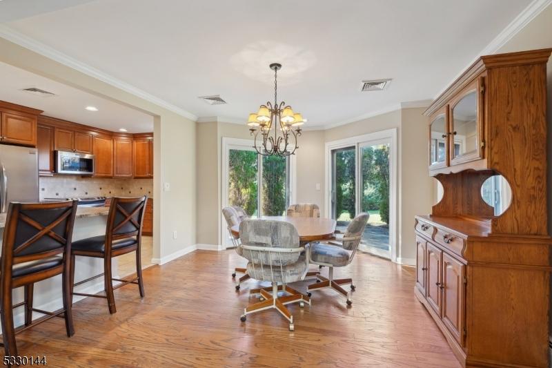 dining room featuring light hardwood / wood-style flooring, an inviting chandelier, and crown molding