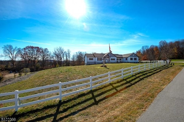 view of front of property with a rural view and a front lawn